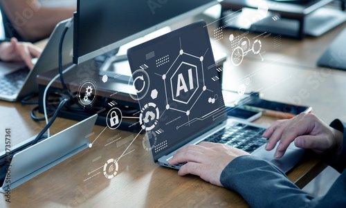 オフィスでノートパソコンを操作する手元とAIインターフェースのコンセプト