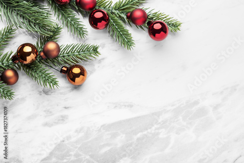 Christmas background, pine branches with christmas balls on marble table, top view