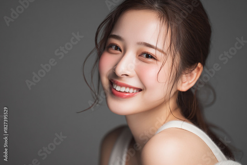 笑顔できらめく綺麗な肌と白い歯を見せる日本人女性美人モデルの接写写真。デンタルケア, オーラルケア、スキンケア、コスメ広告用。