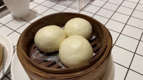 Salted egg baozi or Bakpau Telur Asin placed in bamboo steamer. Steamed chinese dumpling dim sum. Authentic typical chinese food.