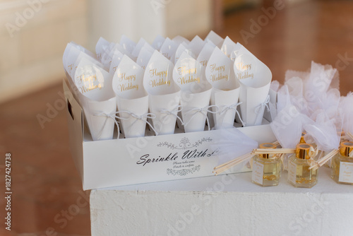 Decorative wedding favors and confetti cones arranged elegantly for guests at a joyful outdoor celebration
