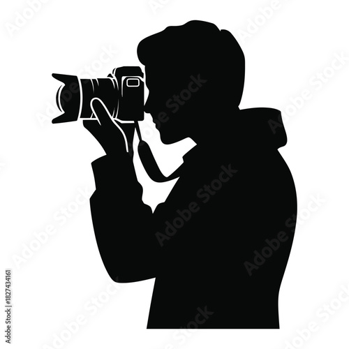 Silhouette of a photographer holding a professional camera and taking a picture