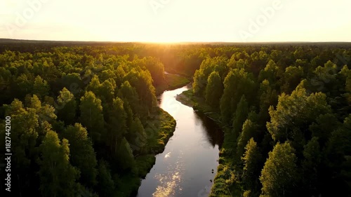 Serene sunrise over the lake and river landscape with mountain reflection and autumn trees under a cloudy sky