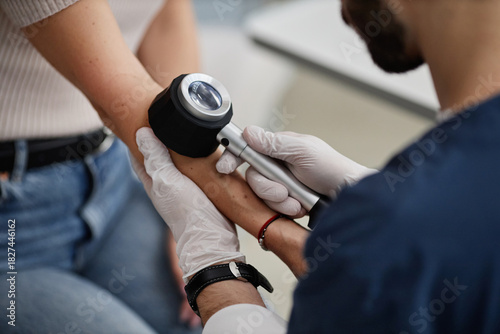 Bild auf Leinwand Woman undergoing skin examination by male dermatologist using dermatoscope on fo
