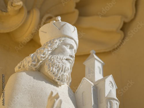Saint Leopold statue white stone holding church against yellow wall Klosterneuburg Abbey Austria