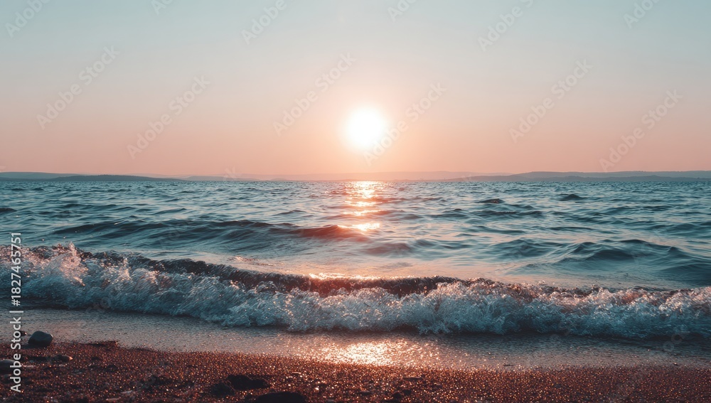 Fototapeta premium Sunset over a tranquil beach. Soft light paints the sea and waves