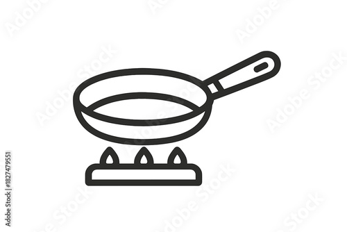 Kitchen frying pan heating over gas flames on a stove top burner cooking food