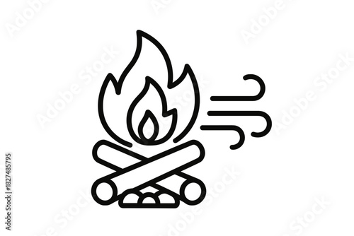 Campfire burning on stacked wood logs with flames being blown sideways by strong wind