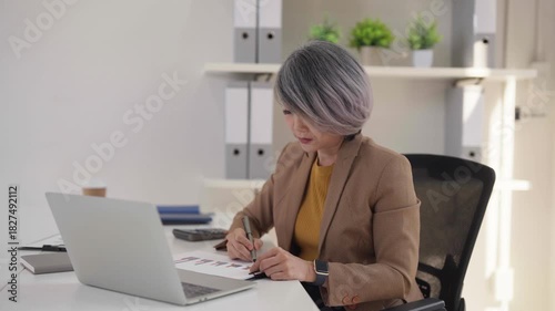 Asian older woman business leader phone call at modern office working professional executive communication technology remote work lifestyle career success