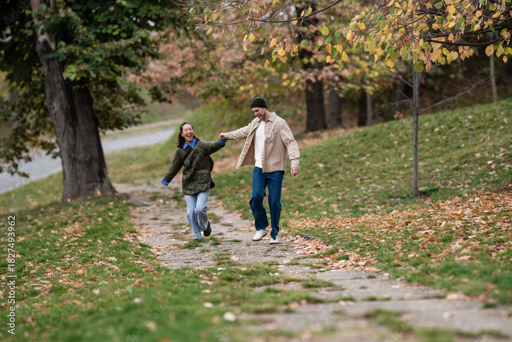 Fototapeta premium Couple running and enjoying autumn park walk