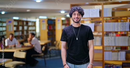 Indian Asian young adult gen z man confident student standing proud look camera indoor book store library happy smiling boy staring cam do casual pose enjoy new day time college