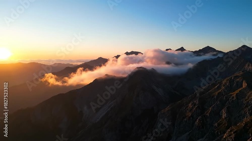 Panoramic view of sunrise over snow-capped mountains, early morning nature landscape in the Alps.