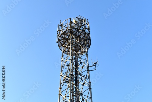 Looking up at a mobile phone tower on a sunny day.