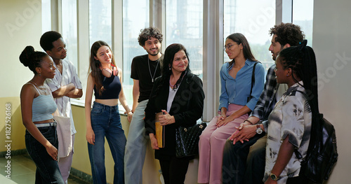 Indian happy young adult tutor lady woman group talk casual gossip have fun joy enjoy new day spend break time indoor place. Teen female girl pupil boy man male guy group mate speak share funny joke