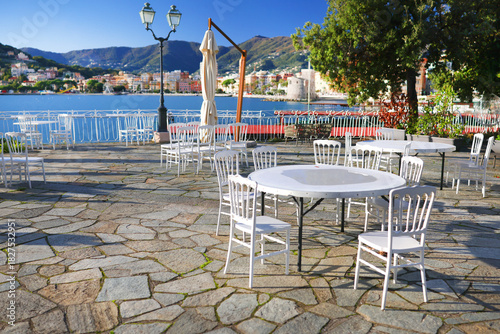 Fototapeta Naklejka Na Ścianę i Meble -  White furniture on terrace by sea on sunny day. Tourism and recreation, Europe. Nature and architecture of Italy. Design backdrop.