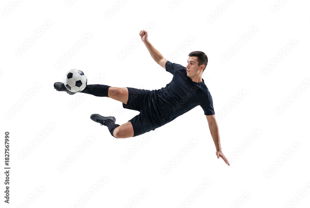 Fototapeta premium Male soccer player performing flying kick in mid air on isolated black background, athletic action and competitive sports concept for training, fitness promotion and team game energy