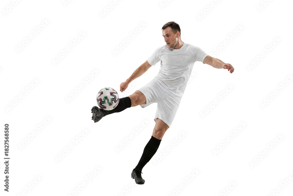 Fototapeta premium Male soccer player kicking ball in mid air on isolated background, athletic action and competitive sports concept for training, coaching materials and youth team promotion