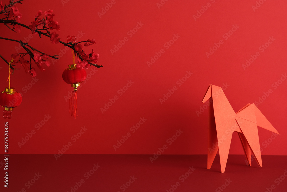 Fototapeta premium Happy Chinse New Year 2026 concept. Red origami horse and two red hanging lanterns against a vibrant red backdrop.