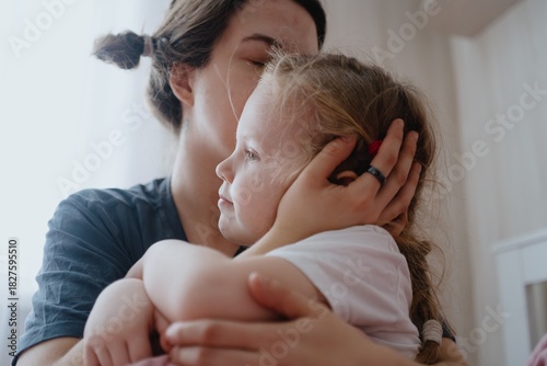 A 4-year-old girl just woke up from nap, stretching in her sunny bedroom. Authentic childhood routine moment with natural morning light and peaceful atmosphere
