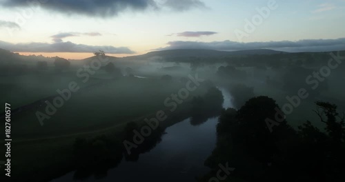 Flying over river in a misty valley