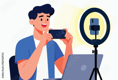 A smiling man records a video with a smartphone, ring light, and laptop