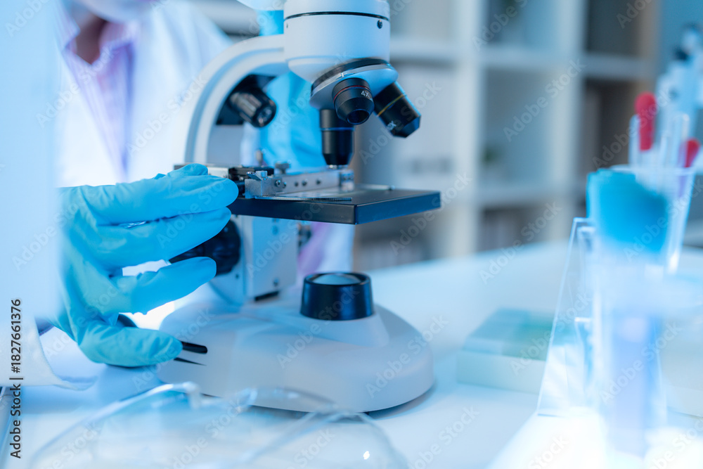 Fototapeta premium A chemistry researcher in a laboratory surrounded by scientific equipment and test tubes, representing innovation, scientific development, and modern medical research environment.