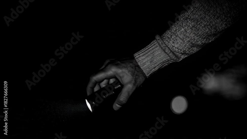 Hand holding a flashlight in the dark, searching for something lost.