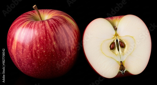 A whole red apple and a half apple with seeds on a black background in a studio setting