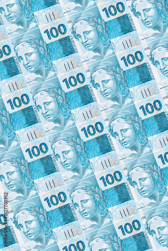 Background texture of Brazilian money bills, 100 reais notes, background for video or scenery. Concept of award or payment, fortune.