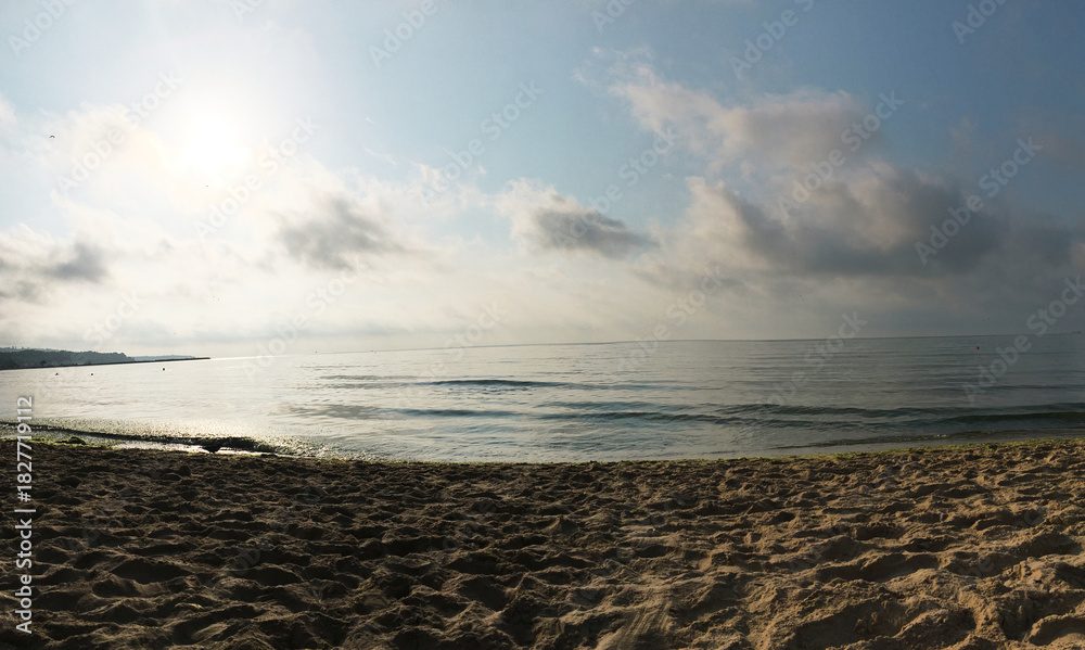Obraz premium An amazing sea view at the sandy beach in the morning. Foamy waves flowing gently toward the shore. Summer vacation in tropical places. Greece sea view. Turquoise waster and blue sky wallpaper.