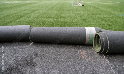 Konzept Sanierung Kunstrasen: Blick auf einen Fußballplatz mit Kunstrasen dessen Untergrund und Spielbelag gerade ausgewechselt wird, viel Copy Space