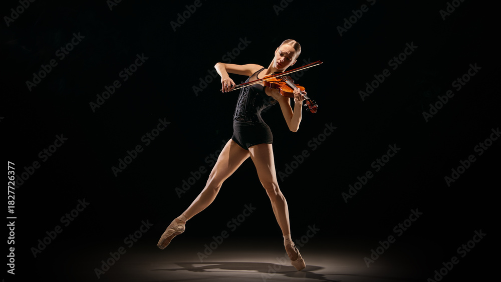 Naklejka premium Violin performance captured mid-air in expressive ballet motion. Concept of body-as-instrument, culture promo visuals, theatre posters, art school materials, dynamic creative movement scenes.