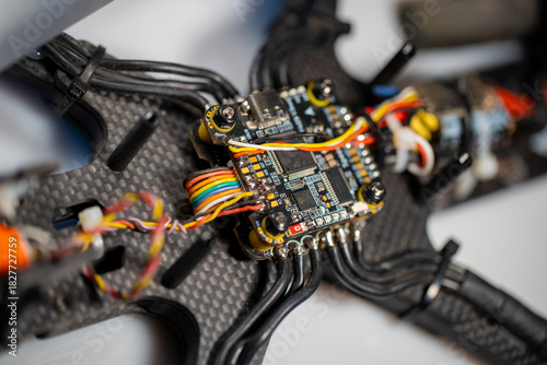 detailed close up of fpv drone electronic components on carbon fiber frame, neutral background, clear negative space, clean composition, balanced framing, minimalist layout, editorial friendly