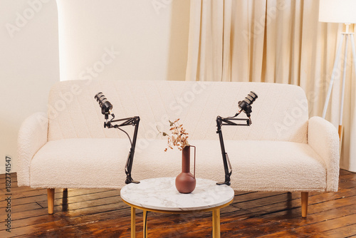 Recording setup featuring microphones and a cozy sofa in a stylish room