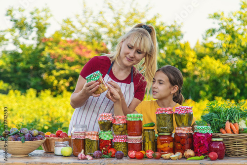 Foto Woman with jar preserved vegetables for winter mother and daughter