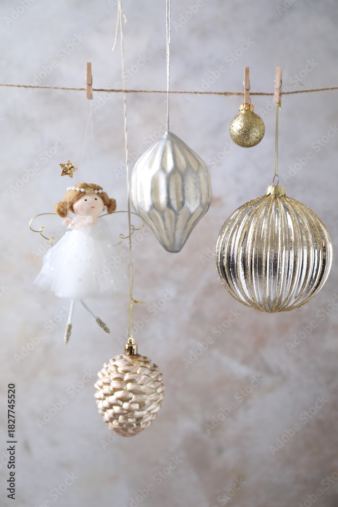 Fototapeta premium Beautiful Christmas decor hanging on string near light grey wall