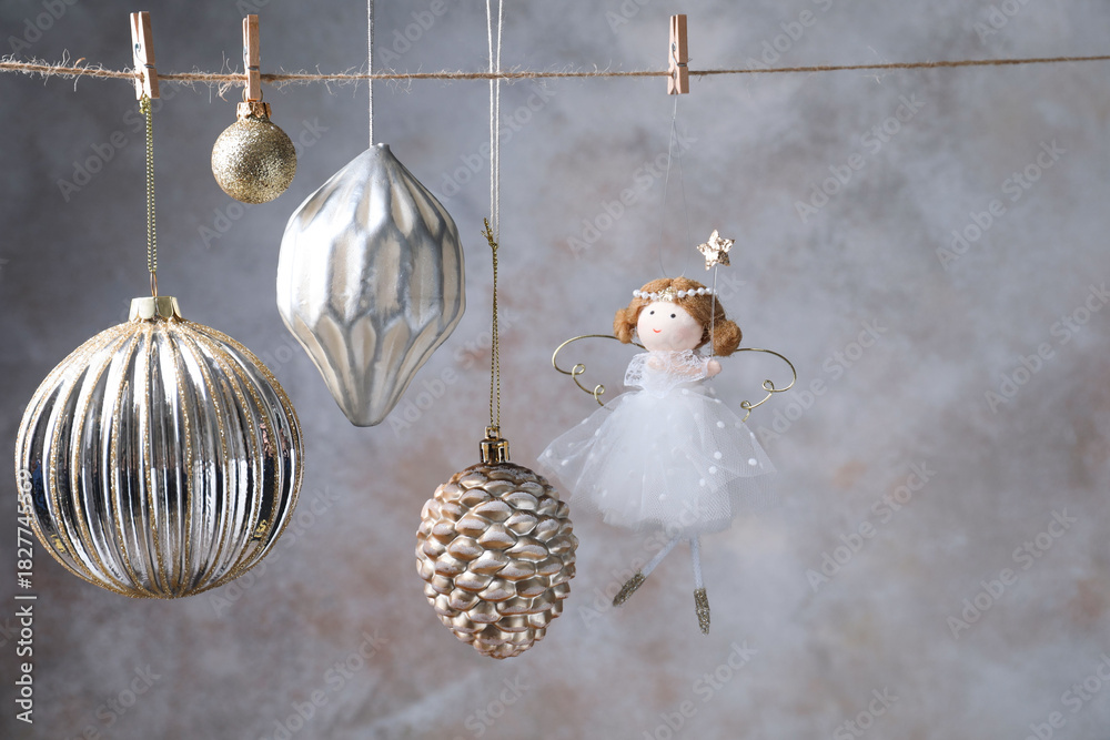 Fototapeta premium Beautiful Christmas decor hanging on string near light grey wall. Space for text