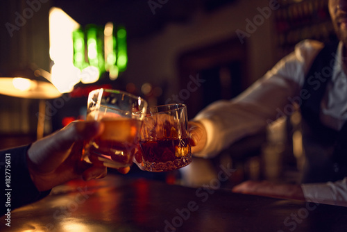 Sticker Hands clicking whiskey glasses in warm bar light