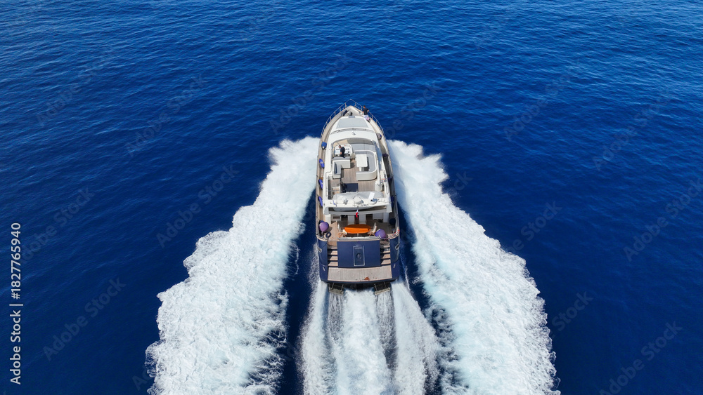 Obraz premium Aerial drone photo of small luxury yacht cruising in deep blue sea near Aegean island, Greece