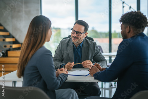 Quadro em tela Financial adviser discussing contract with diverse couple in office meeting