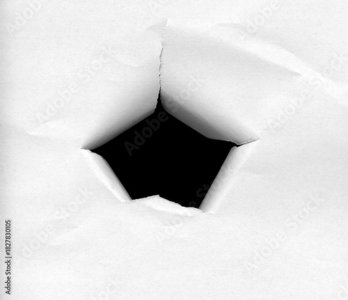 Black hole in paper with torn edges facing inwards.
