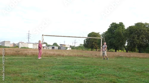 Wallpaper Mural A man and a woman are playing badminton on a sports field, enjoying active outdoor recreation. Torontodigital.ca