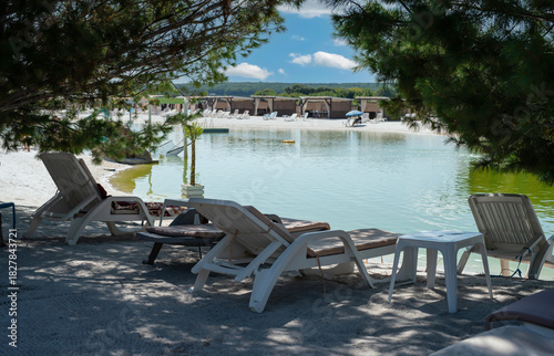 Wallpaper Mural White deck chairs by the lake in the shade between coniferous trees Torontodigital.ca