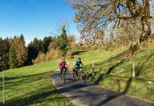nice active senior couple riding their electric mountain bike  in vicinty  of the city of Isny in the Swabian  Allgaeu on warm autumn day, Baden-Wuerttemberg, Germany
