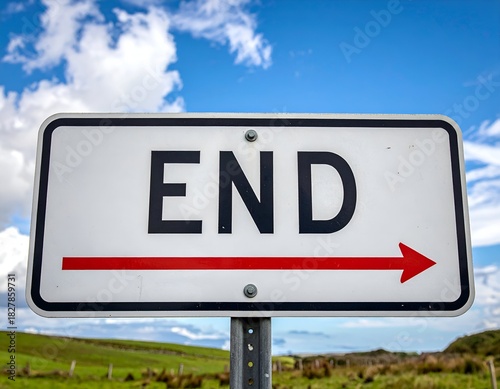 A road sign indicating the end, pointing right with an arrow, set against a blue sky