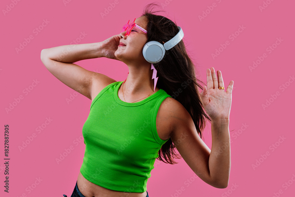 Obraz premium Young woman enjoying music dancing with headphones