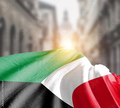 Kuwait flag fluttering on blur street with building. Kuwait national flag for independence day.