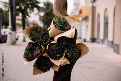 Wallpaper Mural Very nice young woman standing outdoors, holding many beautiful brassica bouquets  Torontodigital.ca