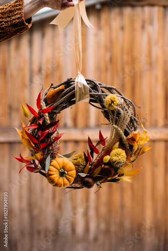 Wallpaper Mural beautiful hand made wreath, decorated with stabilized autumn leaves. and a pumpkin, hanging on the wooden background, close up vertical image Torontodigital.ca