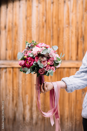 Wallpaper Mural Young woman's hand holding big and beautiful bouquet of fresh roses, peony, eustoma, carnations, eucalyptus flowers in vivd and tender pink colors, close up view  Torontodigital.ca